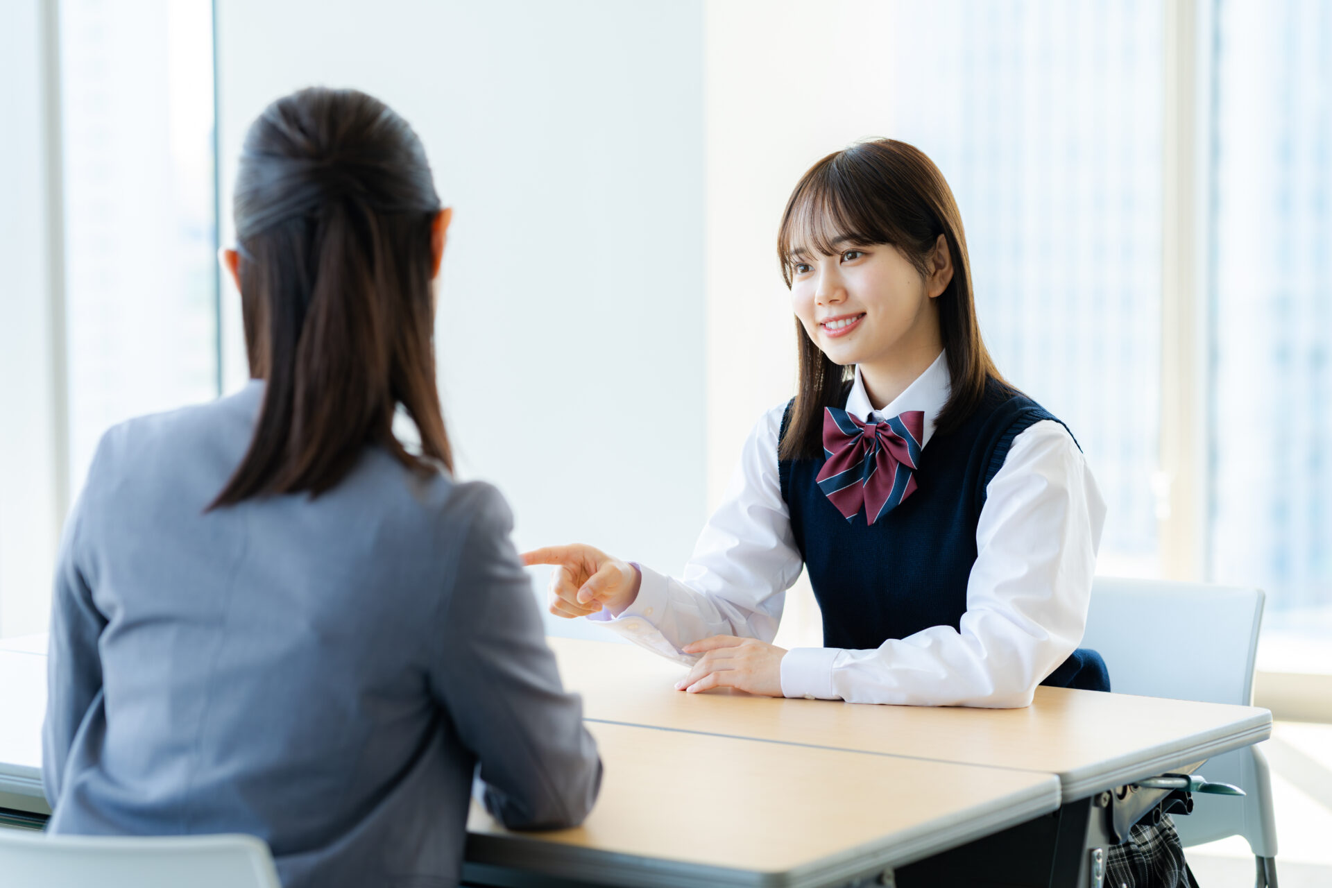 テーブルを挟んで生徒と面談する講師のシーン
